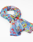 The luxury cashmere scarf with a vibrant Pilbara wildflower design by Sally White, draped in a loose knot.